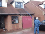 An Aqua Clean cleaner cleaning one of our customers first floor windows from the ground